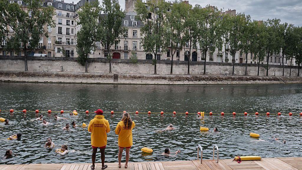 Two lifeguards on duty watching swimmers in the river Seine.