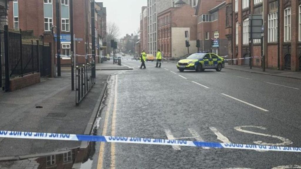 Police cordon and officers at De Montfort University campus in Leicester, with tape across Oxford Street and quiet surroundings.