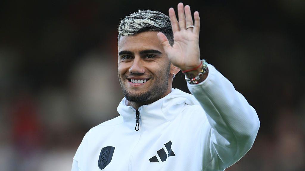 Andreas Pereira waves while smiling