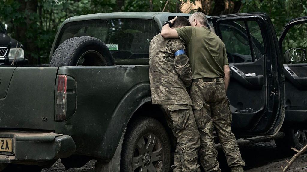 A Ukrainian soldier comforts a comrade during fighting in Kursk