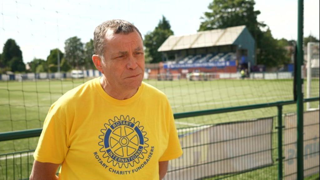 Man standing in a yellow tshirt