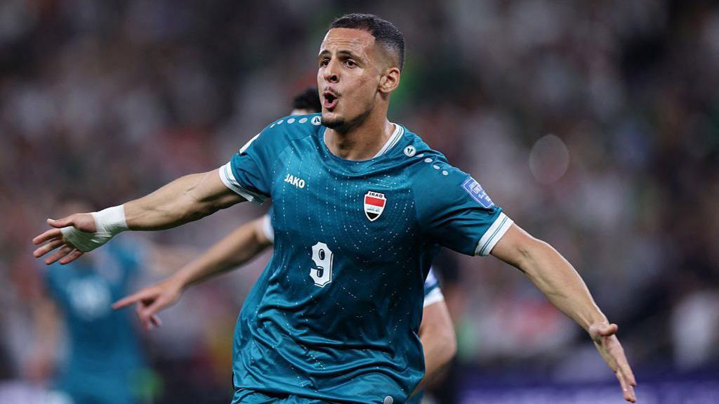Ali Al-Hamadi in a green Iraq kit celebrating his goal against Bolivia