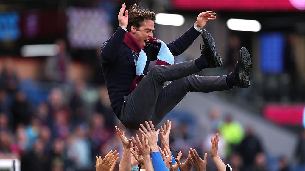 Burnley's players bounce head coach Scott Parker up in the air after sealing promotion to the Premier League