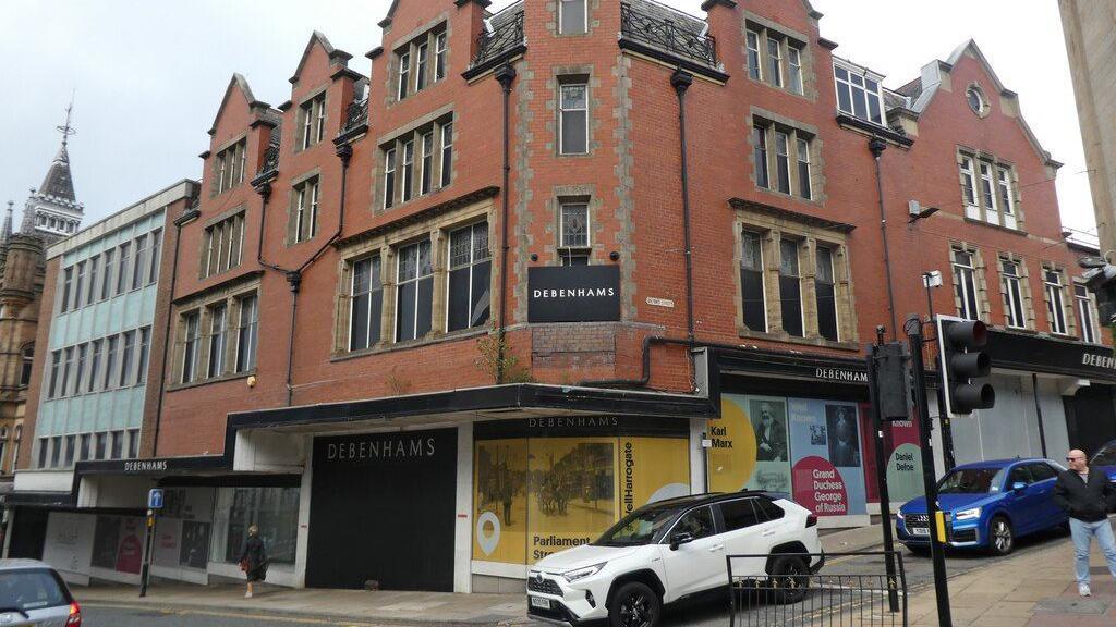 Traffic passes the red-brick former Debenhams building.