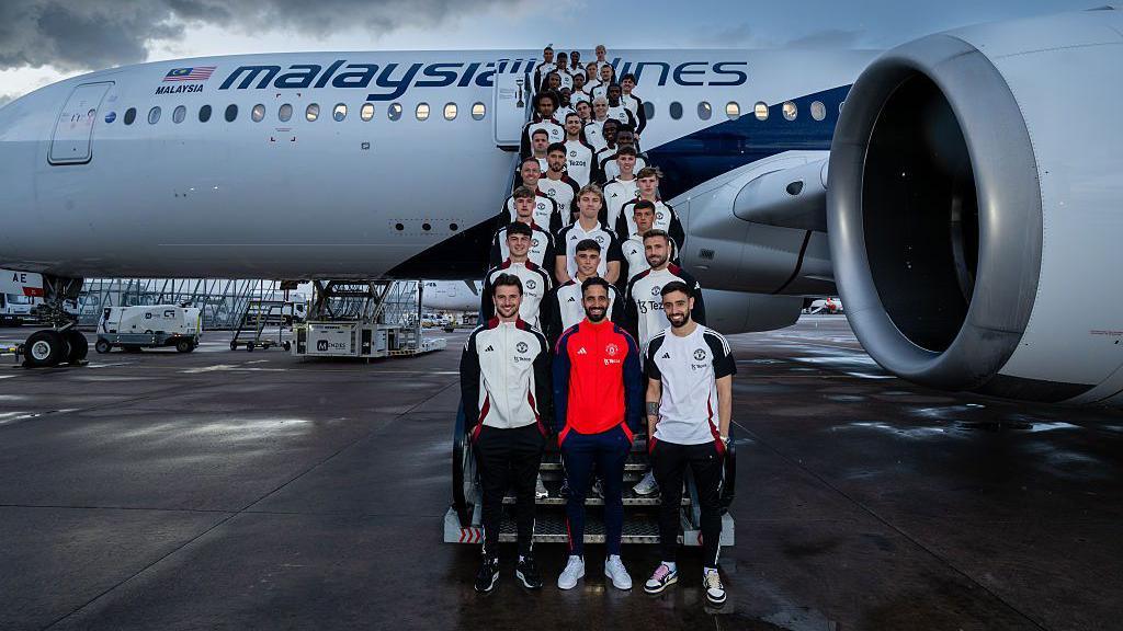 Manchester United players infront of plane
