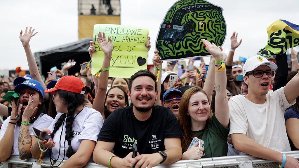 Fans hold up signs in the fan zone in Sao Paulo 