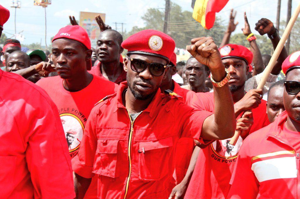 Bobi Wine wearing red overalls at a march with NUP supporters behind him