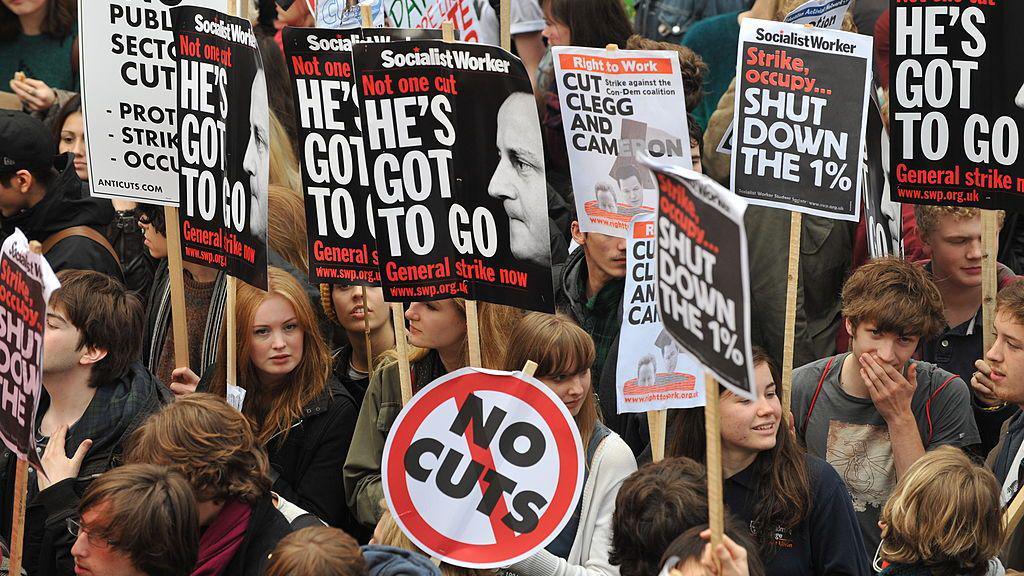 Student demonstrators carry banners as they march against cuts in tuition funding in London on 9 November 2011