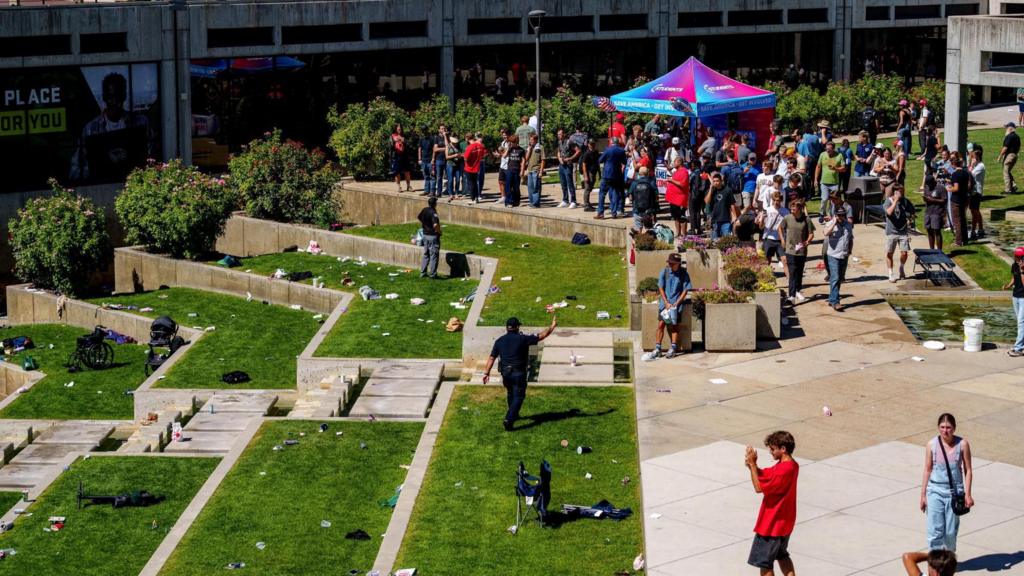 Scene after the shooting showing empty grass and gazebo with onlookers