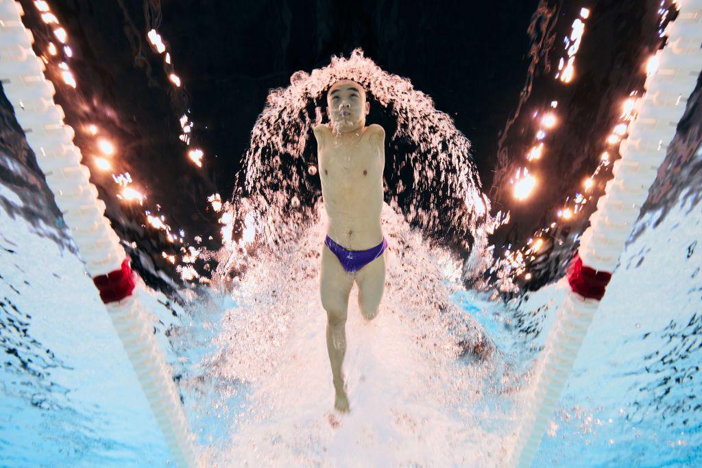 jincheng guo is photographed from below the surface of the swimming pool water while using only his legs to swim 