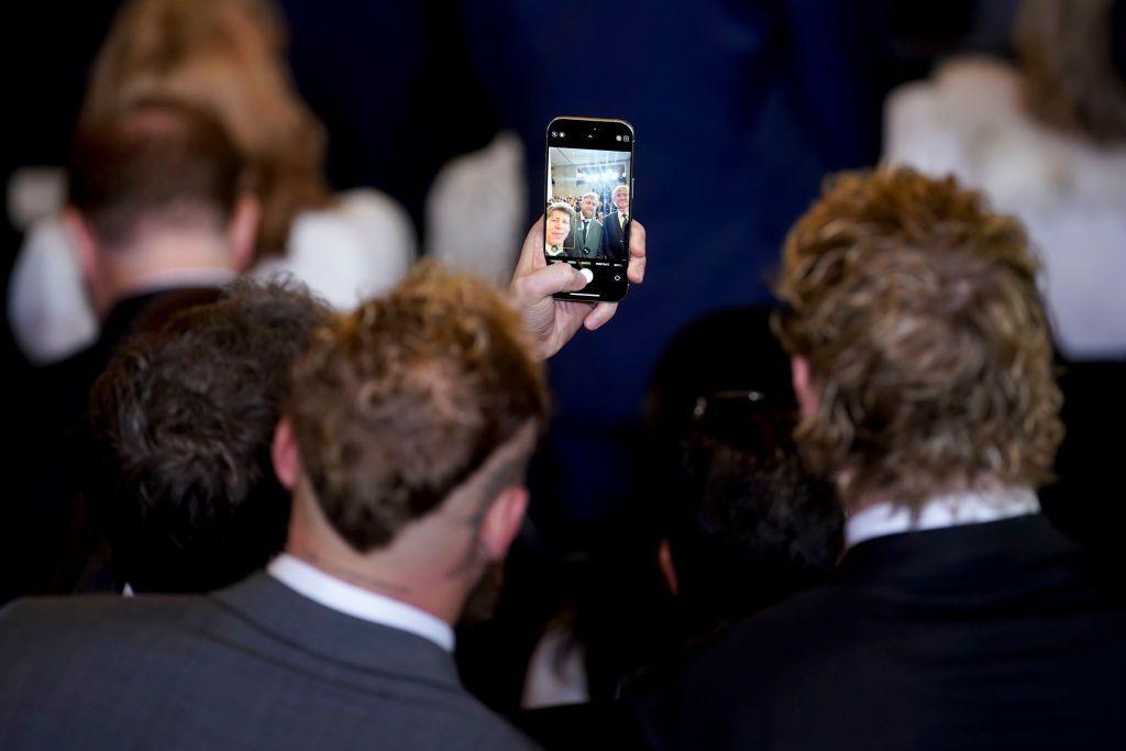 Sam Altman takes a photo on his phone of him, Jake and Logan Paul