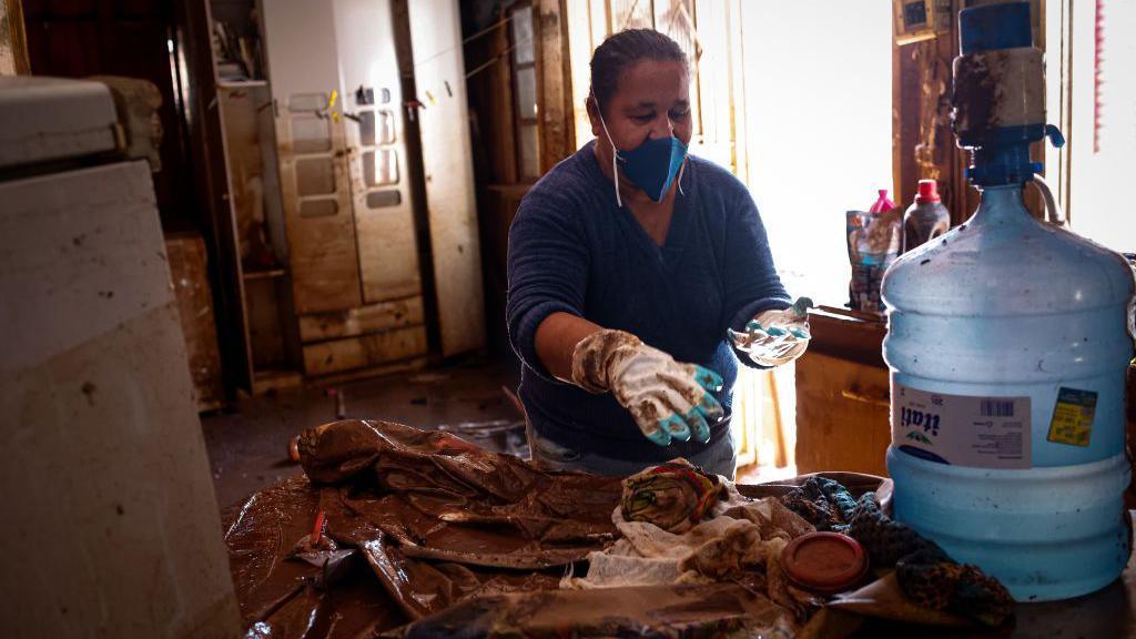 A resident sorts damaged personal belongings at a home following historic flooding in Eldorado do Sul, Rio Grande do Sul state, Brazil, on Wednesday, May 22, 2024. 