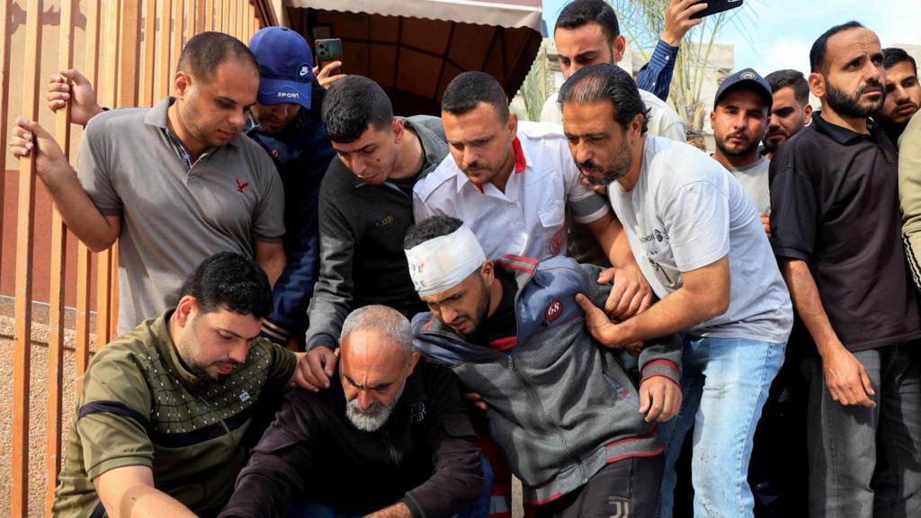 Group of looking concerned in Gaza in front of injured person