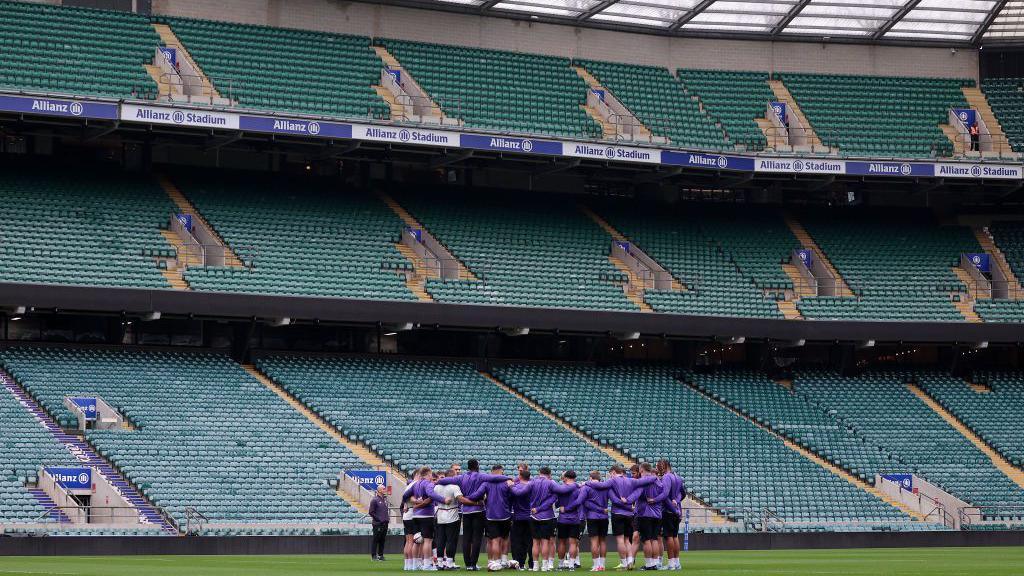 England huddle up in front of empty Twickenham stands