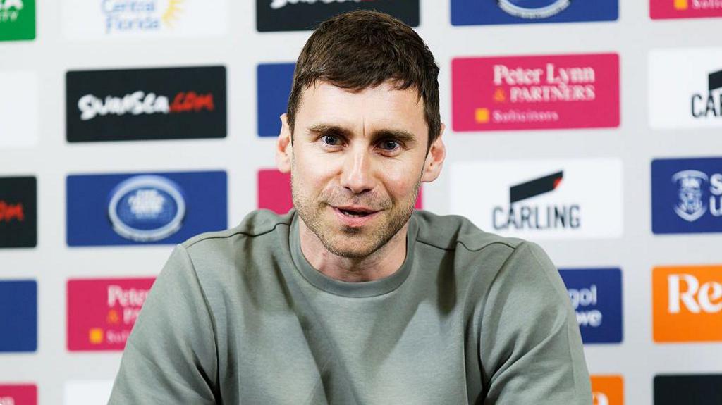 Richard Montague sits at his press conference when he joined Swansea City