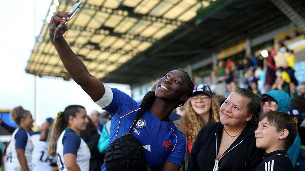 Nassira Konde takes a picture with fans in the crowd