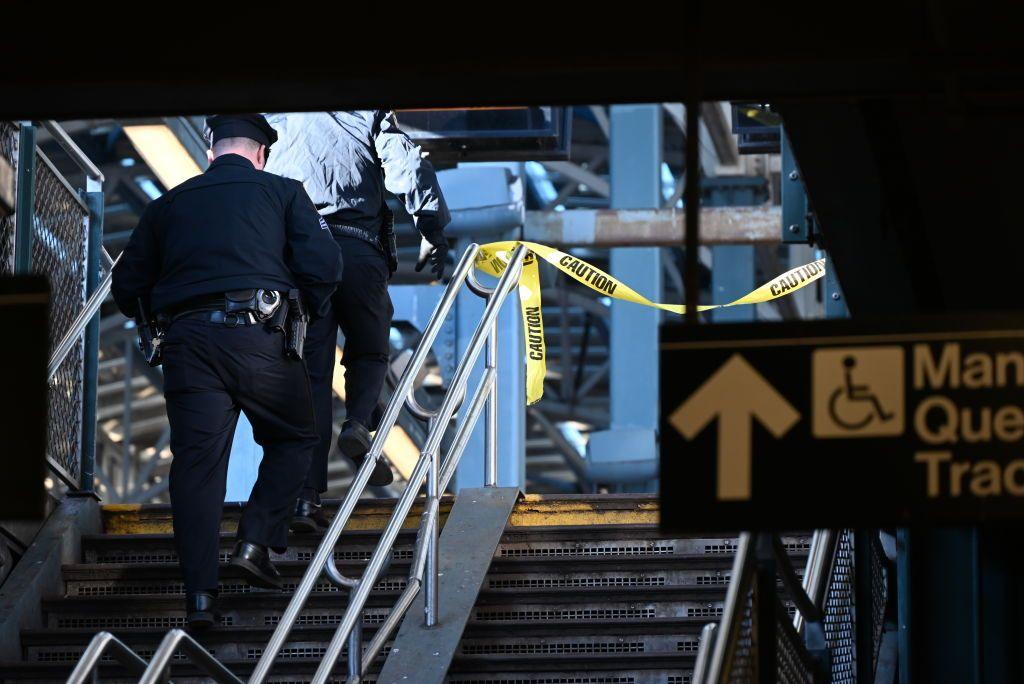 A shot of two police officers from behind walking up a staircase at a subway station