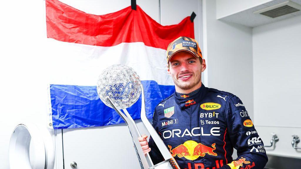 Max Verstappen holding a trophy after he became world champion in 2022