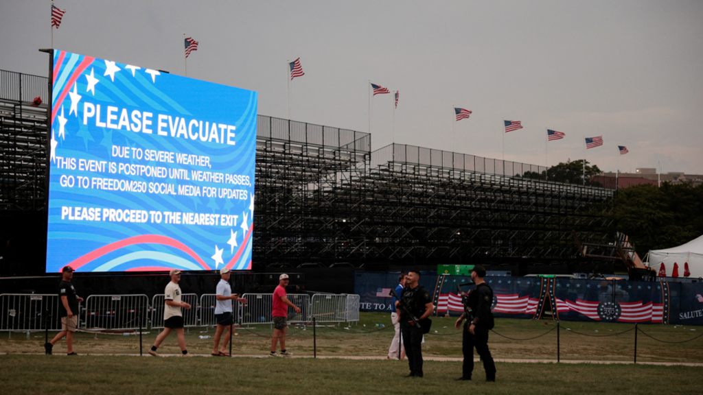 An evacuation notice is displayed on a screen as a storm approaches during Fourth of July celebrations marking the 250th anniversary of U.S. independence