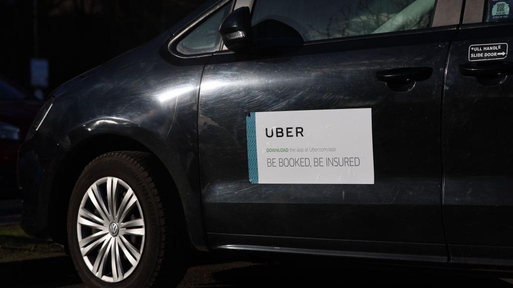 A Uber logo is displayed on a Uber taxi car