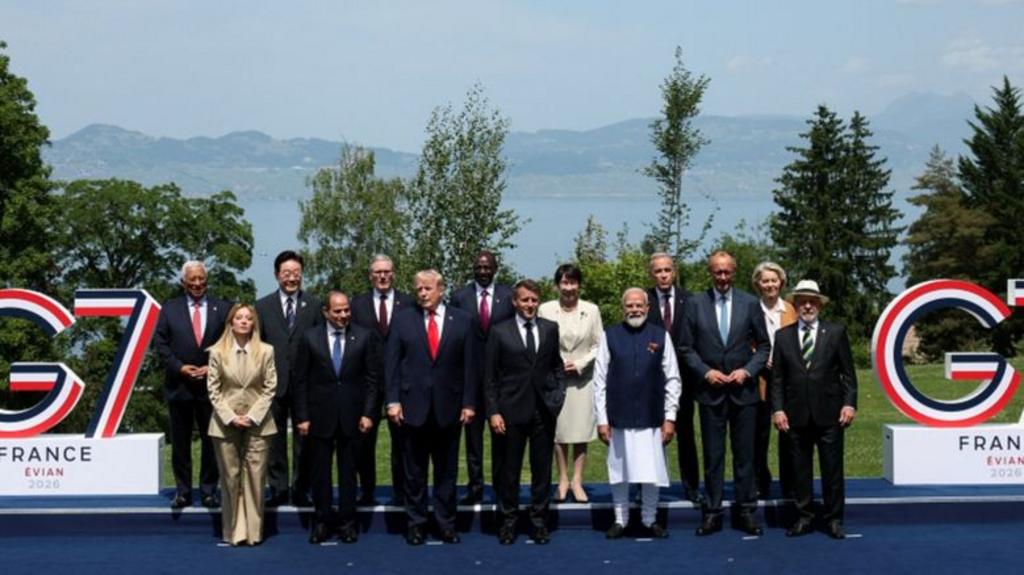 G7 leaders pose in front of a sea view and G7 signs for a family photo