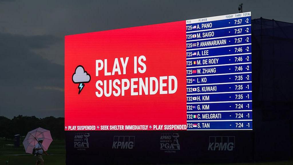 Weather warning messages are displayed on LED boards around the course as play is suspended ahead of the final round of the Women's PGA Championship 2026 at Hazeltine National Golf Club