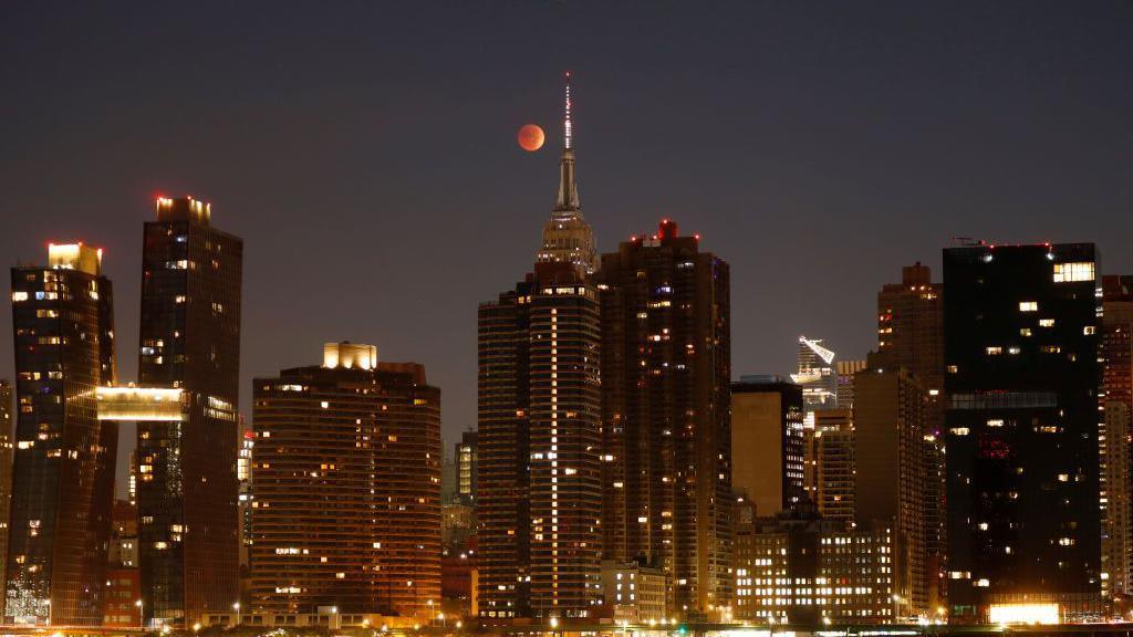 The blood-red Moon passes behind the Empire State Building during a total lunar eclipse in New York City in 2022.