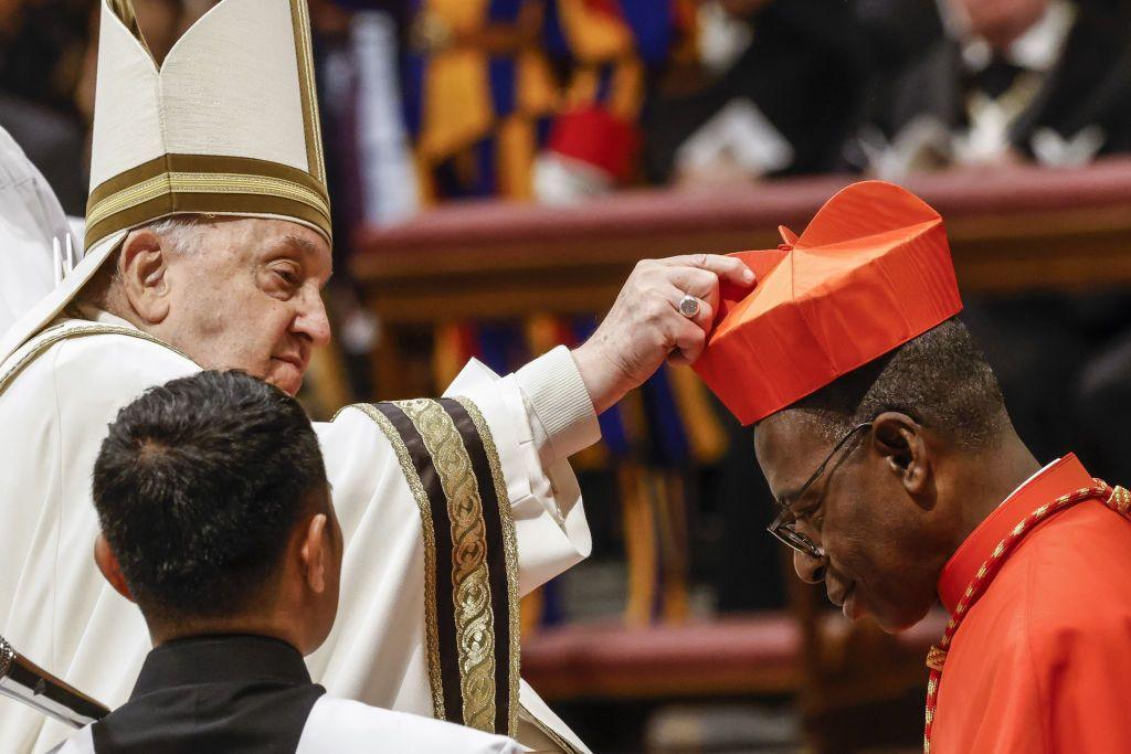 Ignace Bessi Dogbo (R) bows his head as he receives his red biretta from Pope Francis (L) in St Peter's Basilica at the Vatican - Saturday 7 December 2024