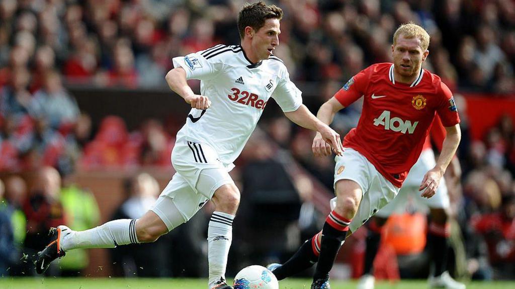 Joe Allen yn chwarae dros Abertawe'n erbyn Manchester United gyda Paul Scholes yn y cefndir