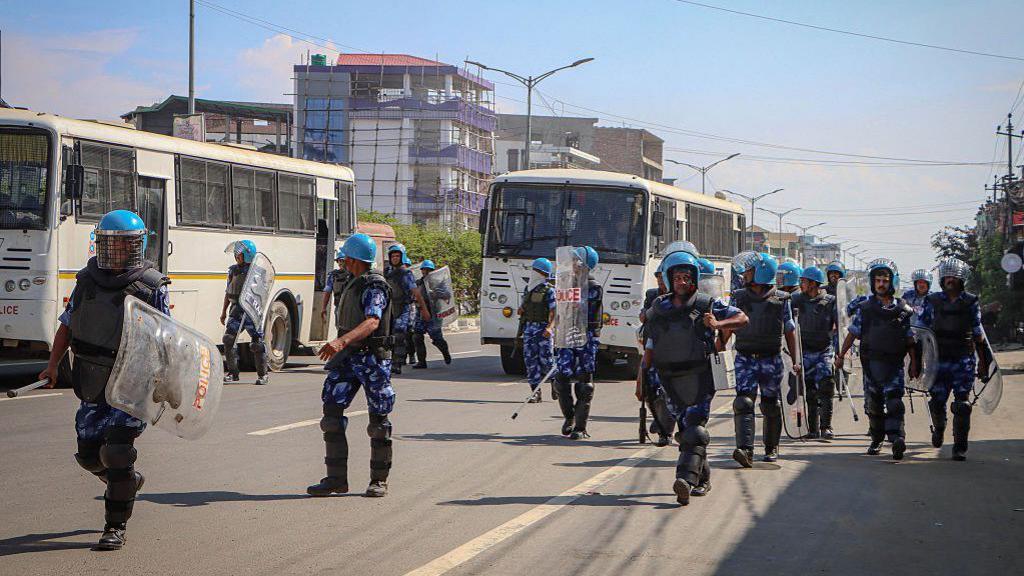 Rapid Action Force personnel patrol along the streets during a curfew in Imphal on June 8, 2025