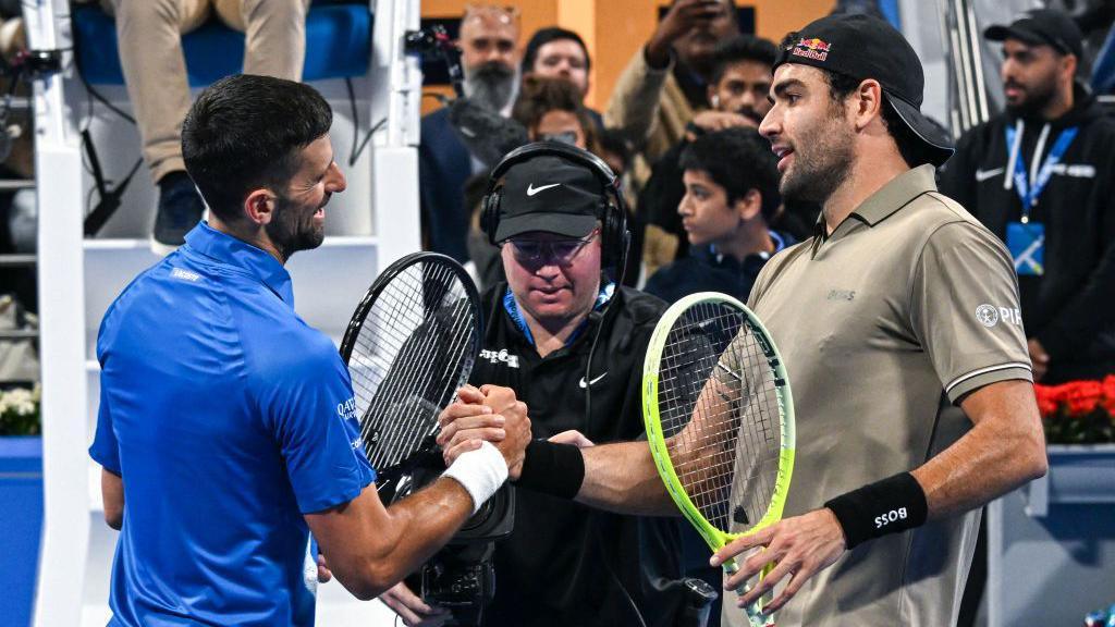 Matteo Berrettini shakes hands with Serbia's Novak Djokovic 