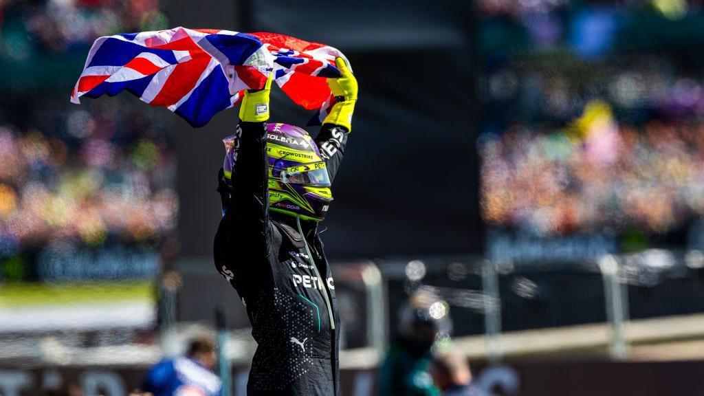 Lewis Hamilton holds up a Union Jack flag
