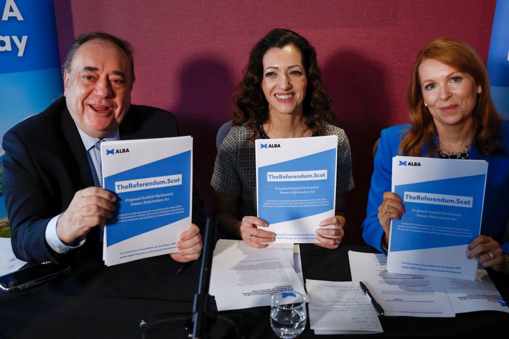 Alex Salmond, Tasmina Ahmed-Sheikh and Ash Regan sit at a desk, all three holding a policy booklet entitled 'The Referendum'