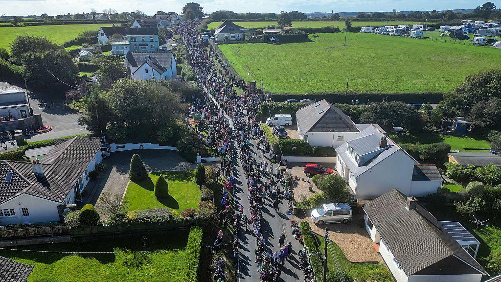 An aerial view of the cycle course with crowds standing alongside a country road