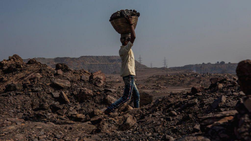 A worker in the Jharia coal mine are carrying blocks of coal in basket on top of his head. According to the World Economic Forum, in 2020, India was home to six out of 10 of the world's most polluted cities.