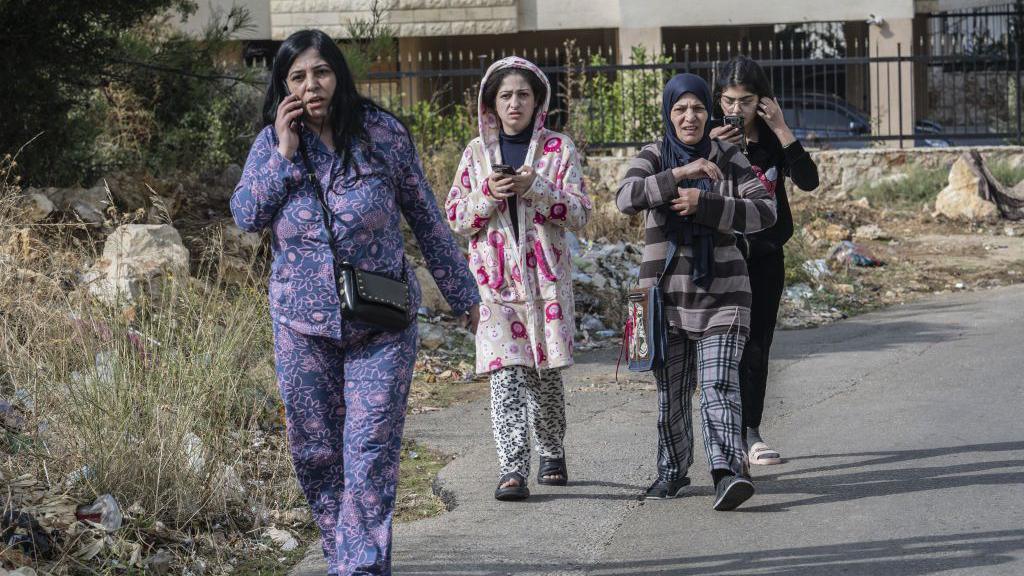 Women leave an area where a residential building was hit in an Israeli strike, in Aramoun, Lebanon (13 November 2024)