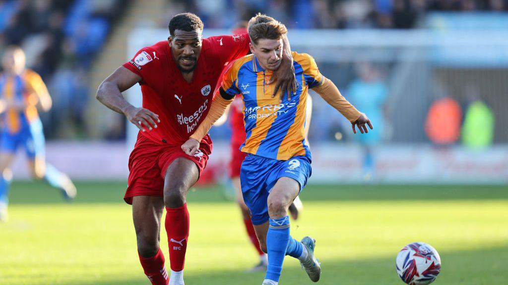 Barnsley's Donovan Pines (left) grapples for possession with Shrewsbury Town front player George Lloyd during the visitors' 2-0 win at Croud Meadow