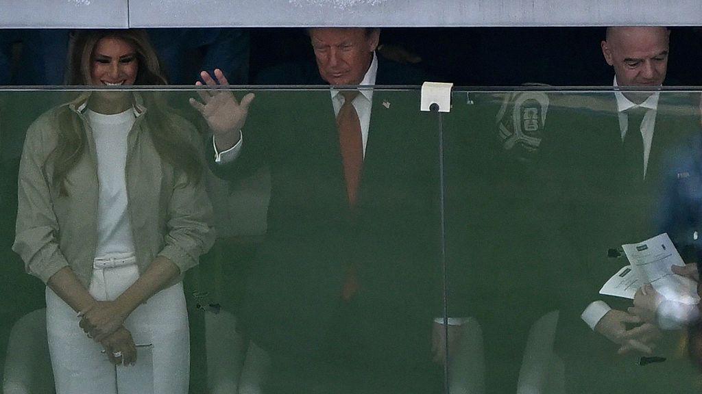 Donald and Melania Trump watching from behind a glass screen
