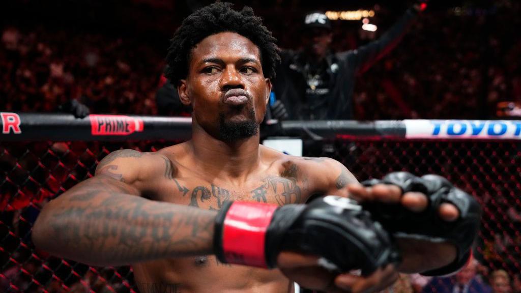 Kevin Holland purses his lips and stretches before a fight begins