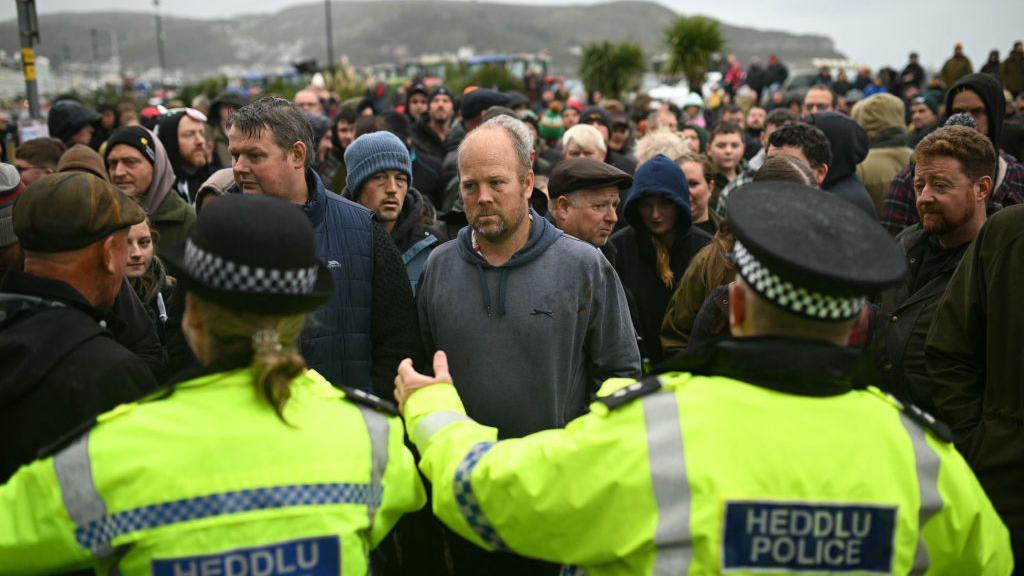 A group of protesters facing police in Llandudno