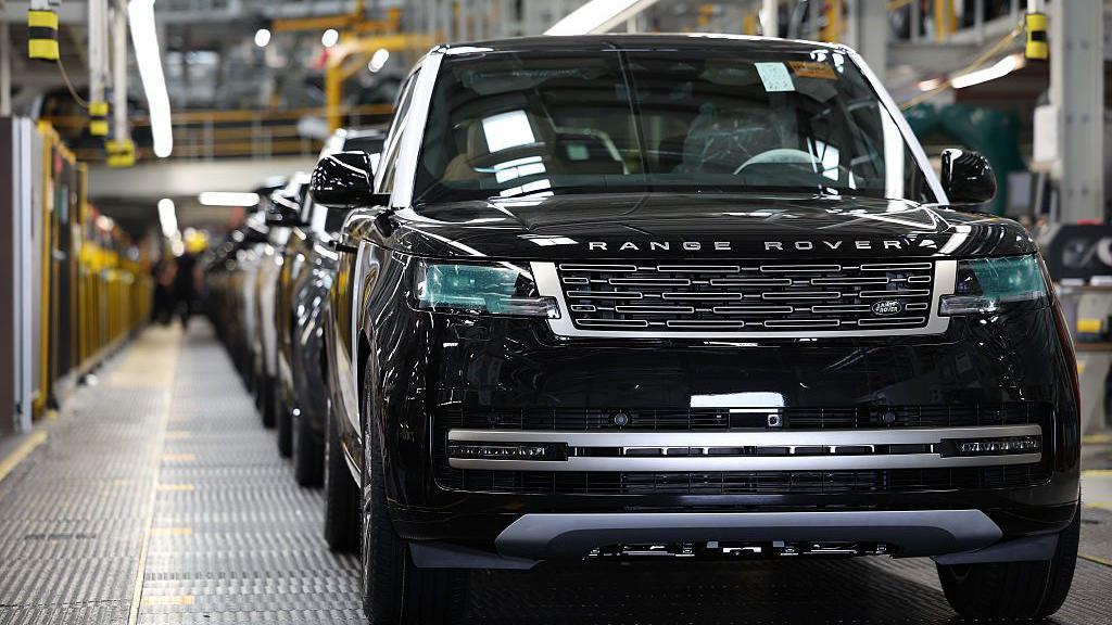 A black Range Rover on a car production line