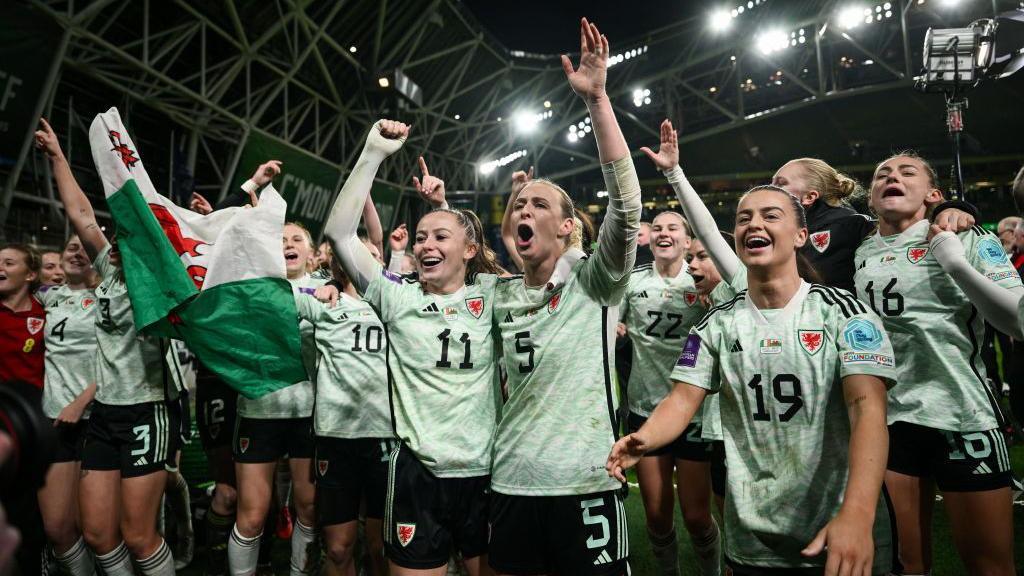 The Wales team, including Hannah Cain, Rhiannon Roberts and Ella Powell, celebrate after the UEFA Women's EURO 2025 Play-off Round Two second leg match between Republic of Ireland and Wales at the Aviva Stadium in Dublin