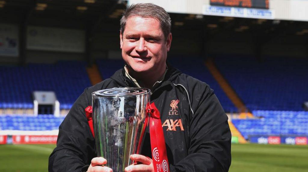 Liverpool Women manager Matt Beard holds the Women's Championship trophy ahead of kick-off between Liverpool and Sheffield United in 2022