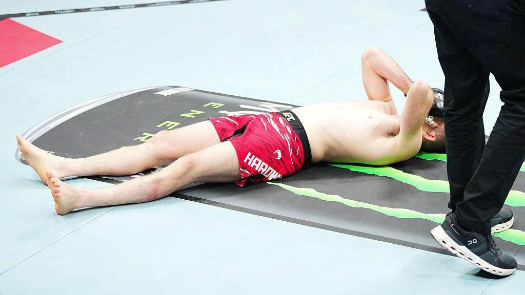 Harry Hardwick lies on the octagon ground after losing his fight with Kaue Fernandes