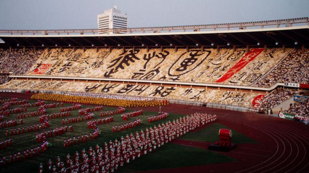 Beijing's Workers' Stadium with fans holding up signs and dancers on the stadium floor to mark the opening of the Asian Games