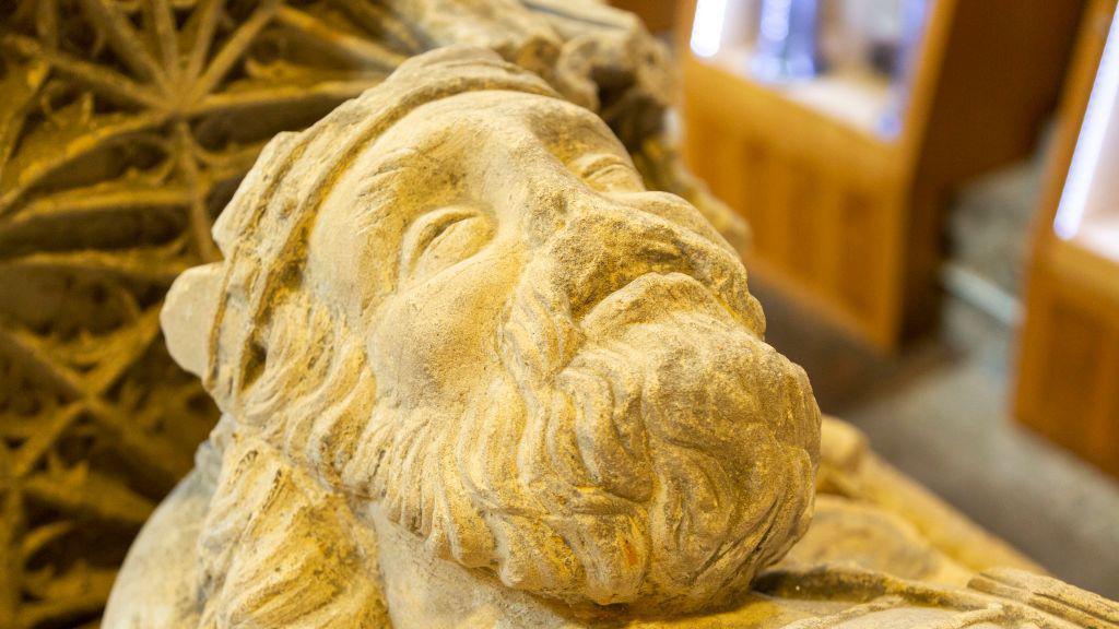 A stone model of a king with a beard and crown