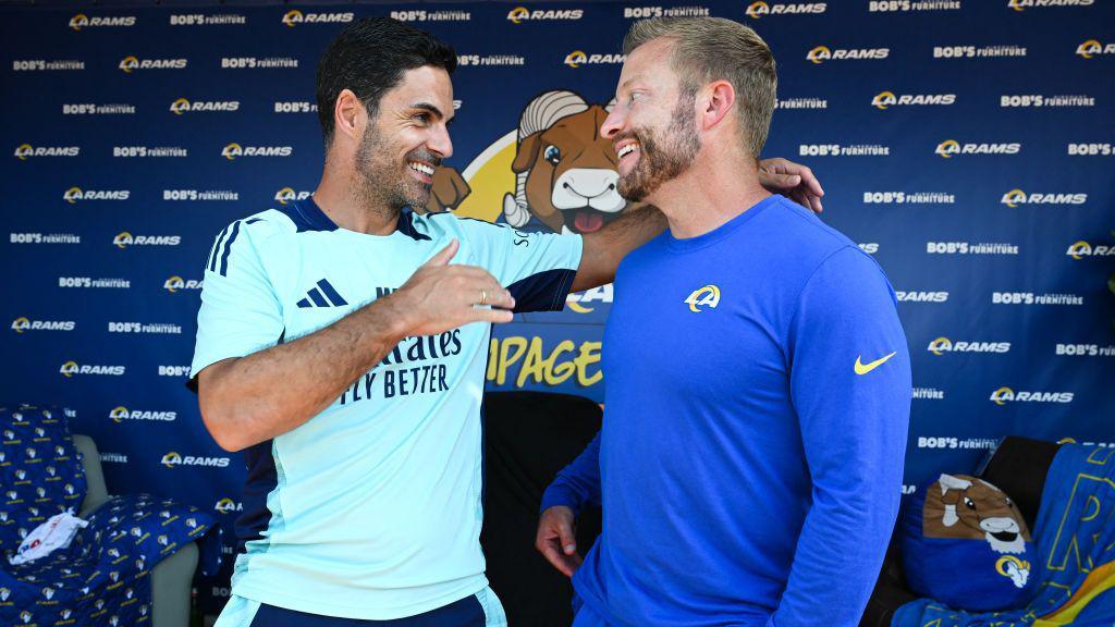 An image of Arsenal Manager Mikel Arteta (L) chatting with LA Rams Head Coach Sean McVay talk during the "Football Meets Football" Youth Clinic at the LA Rams NFL training camp on the Loyola Marymount University