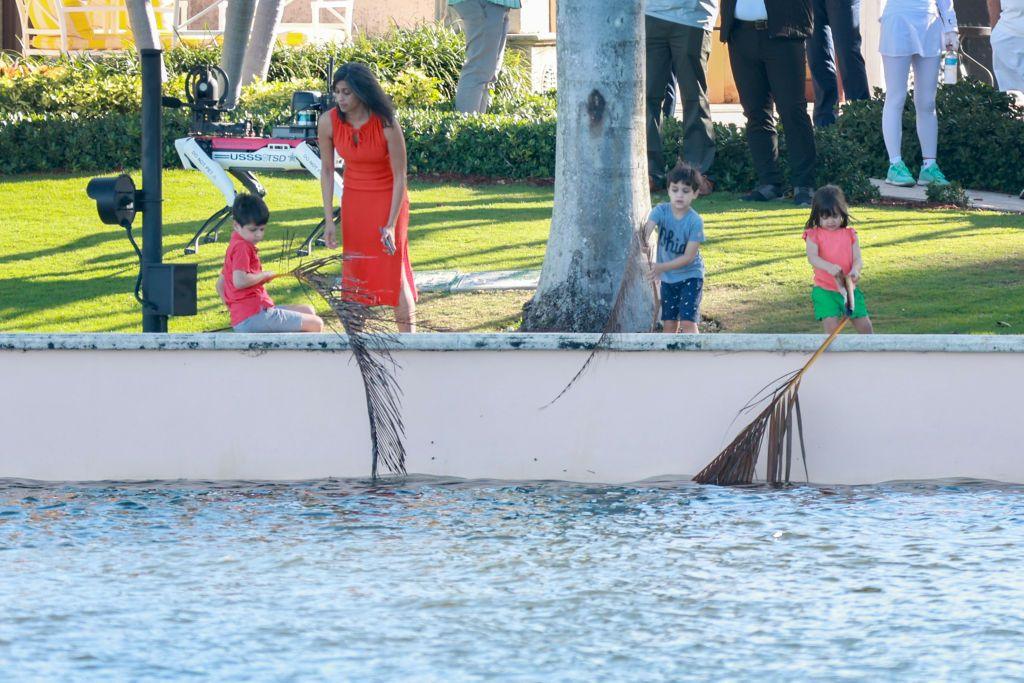 Woman and three kids look over waterway