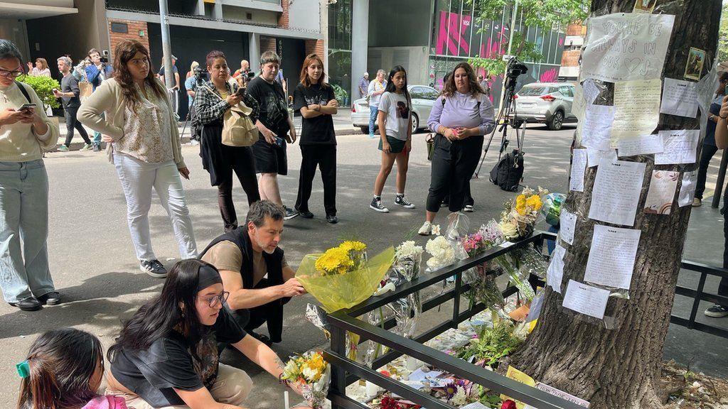 People leave flowers and notes outside the hotel where Liam Payne died