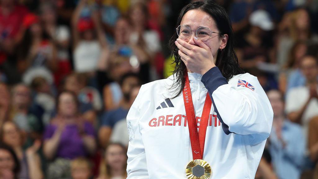 Gold medalist Alice Tai of Team GB on the podium with her gold medal at the Paralympic games.